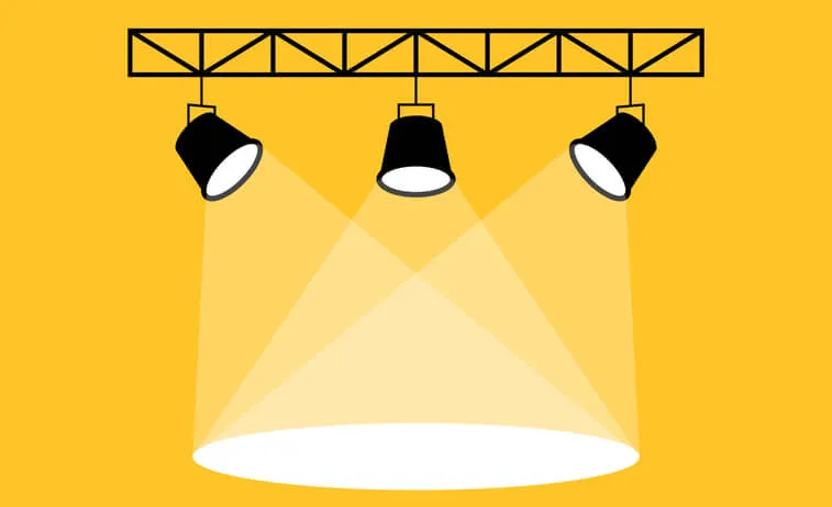 Three black spotlights cast overlapping beams onto a white oval against a yellow background.